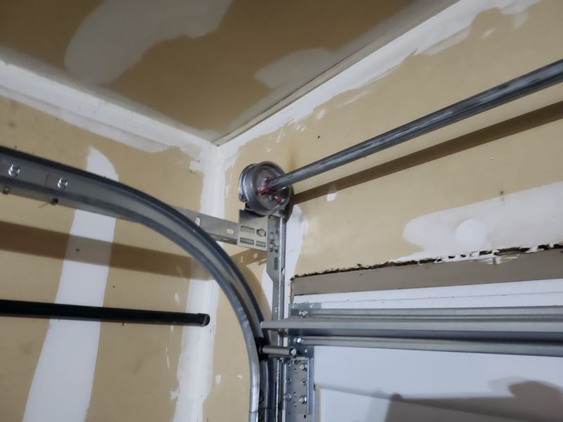 Track and cable drum on a garage door repair in Cross Roads, TX