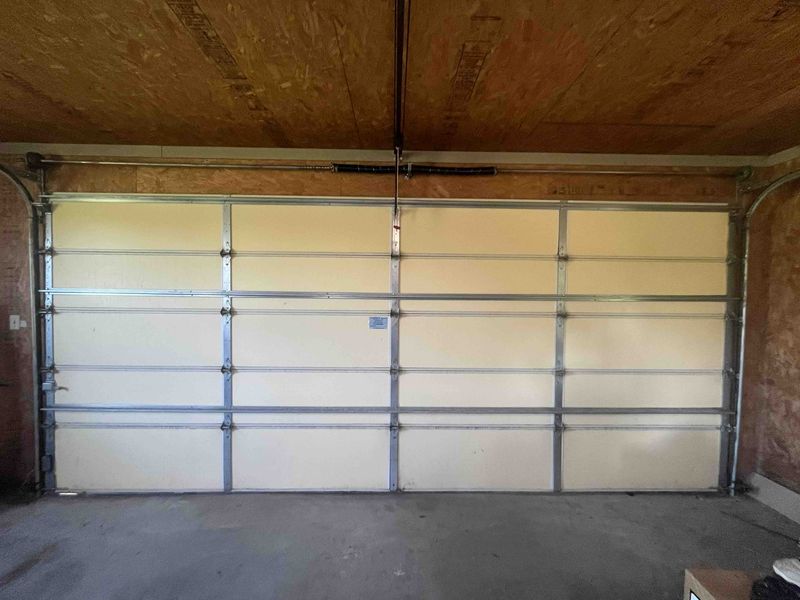 Inside view of a double garage door after a spring replacement in Farmersville, TX