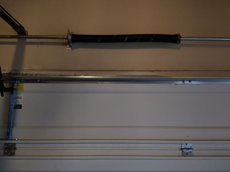 Torsion spring on a white garage door after repair in Glenn Heights, TX