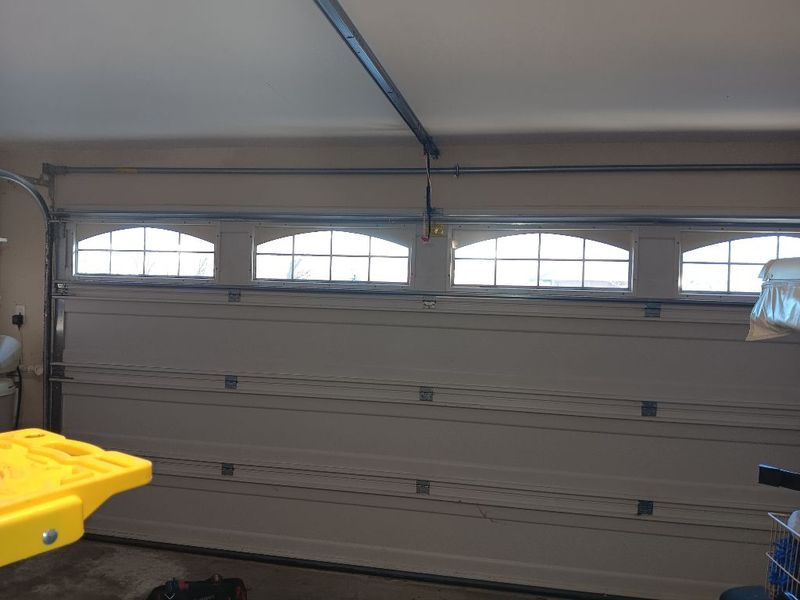 Double garage door with a window row after a safety tune-up in Granbury, TX