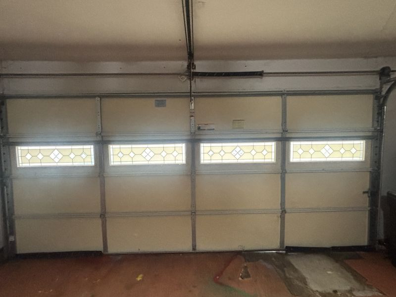 Double garage door with a window row after a balance adjustment in Greenville, TX