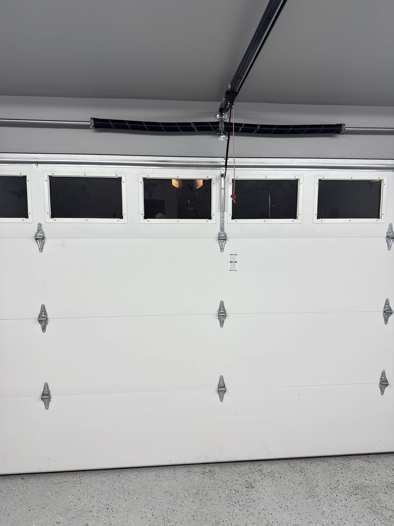 White double garage door with window row after spring replacement in Hurst, TX