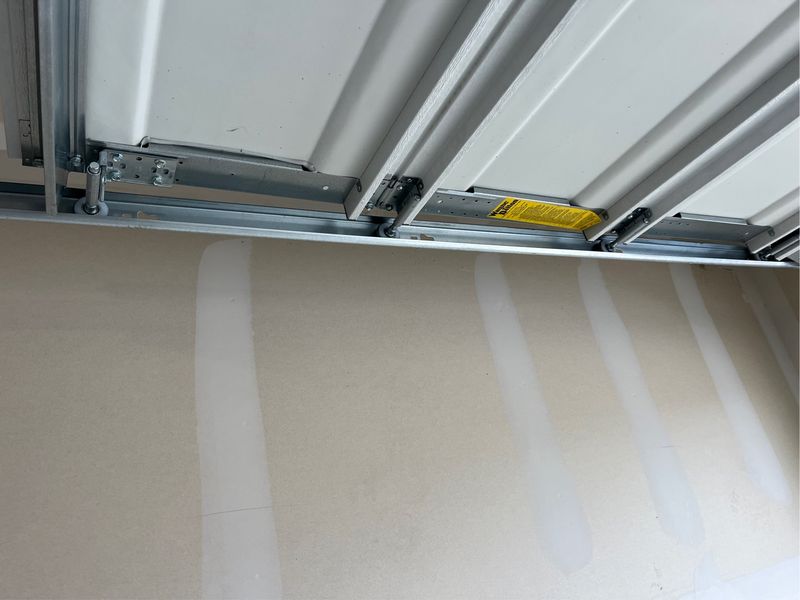 Garage door tracks and rollers checked during a safety tune-up in Hutchins, TX