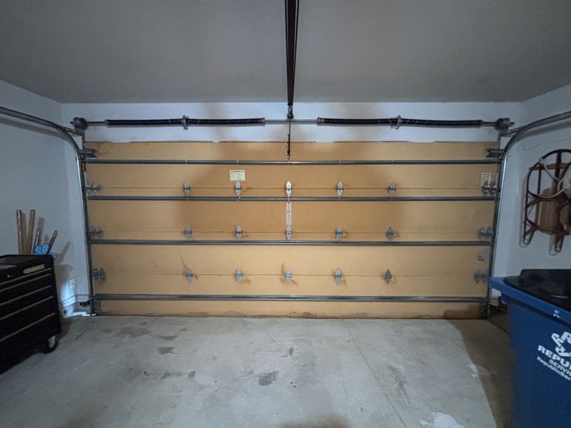 Wood-look double garage door after a repair in Lantana, TX