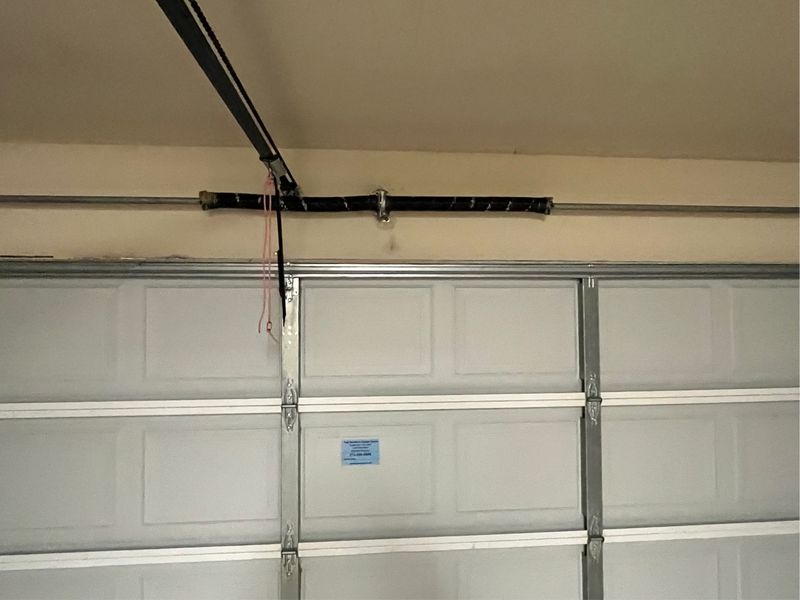 Torsion spring above a double garage door during a service call in Lavon, TX