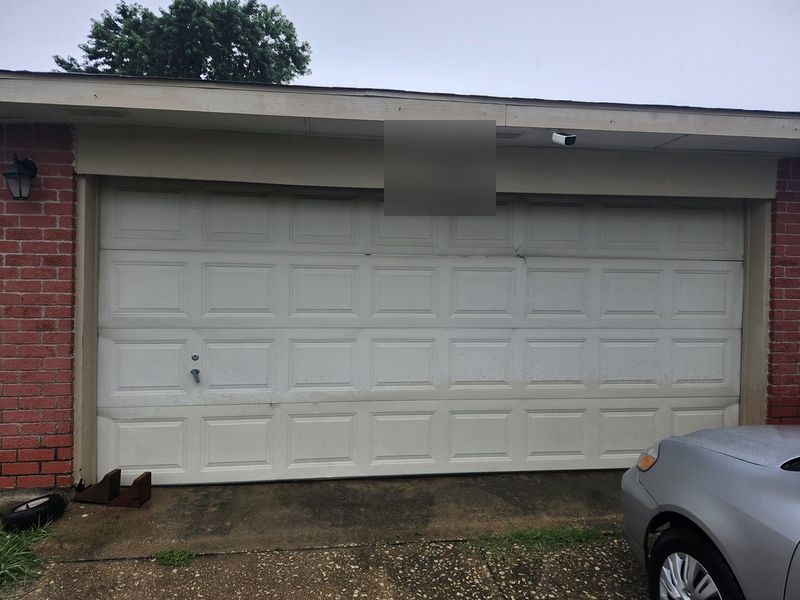 New white raised-panel double garage door installed on a brick home in Mesquite, TX