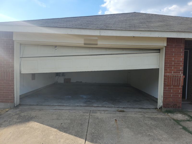 Garage door knocked off its tracks before repair in Terrell, TX (before)