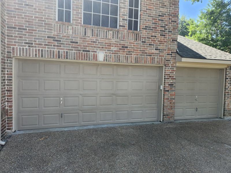 Two new tan raised-panel garage doors installed in McKinney, TX