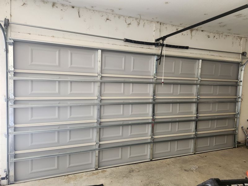 New white raised-panel double garage door with torsion spring in Terrell, TX