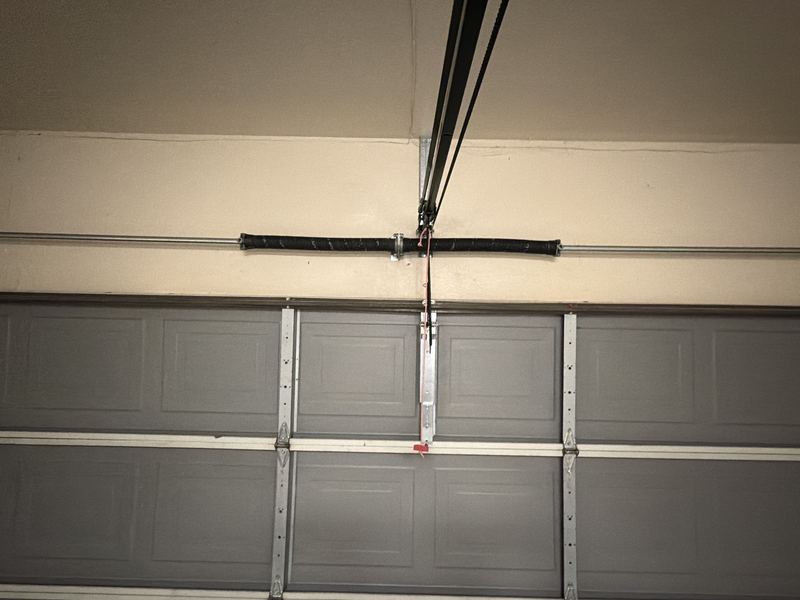 Replacement torsion spring on a gray steel garage door in Coppell, TX